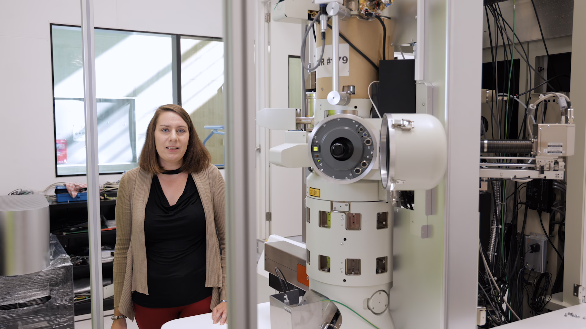 Wiebke Albrecht next to the AMOLF transmission electron microscope (TEM)