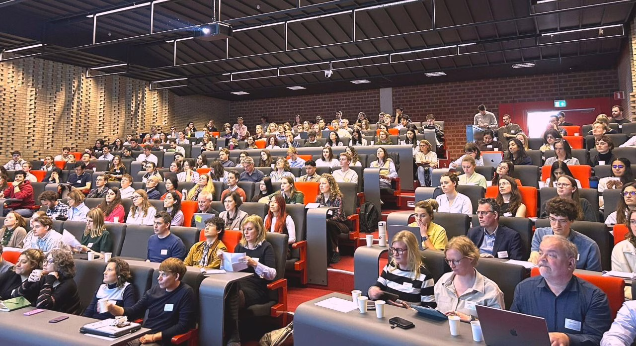 Audience seated in a lecture hall at AMOLF during the 2026 OrganoidNL Symposium, listening to presentations.
